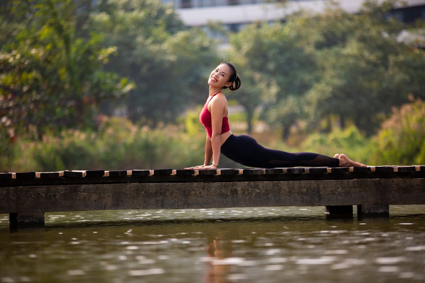 Woman practising yoga outdoors on a bridge
