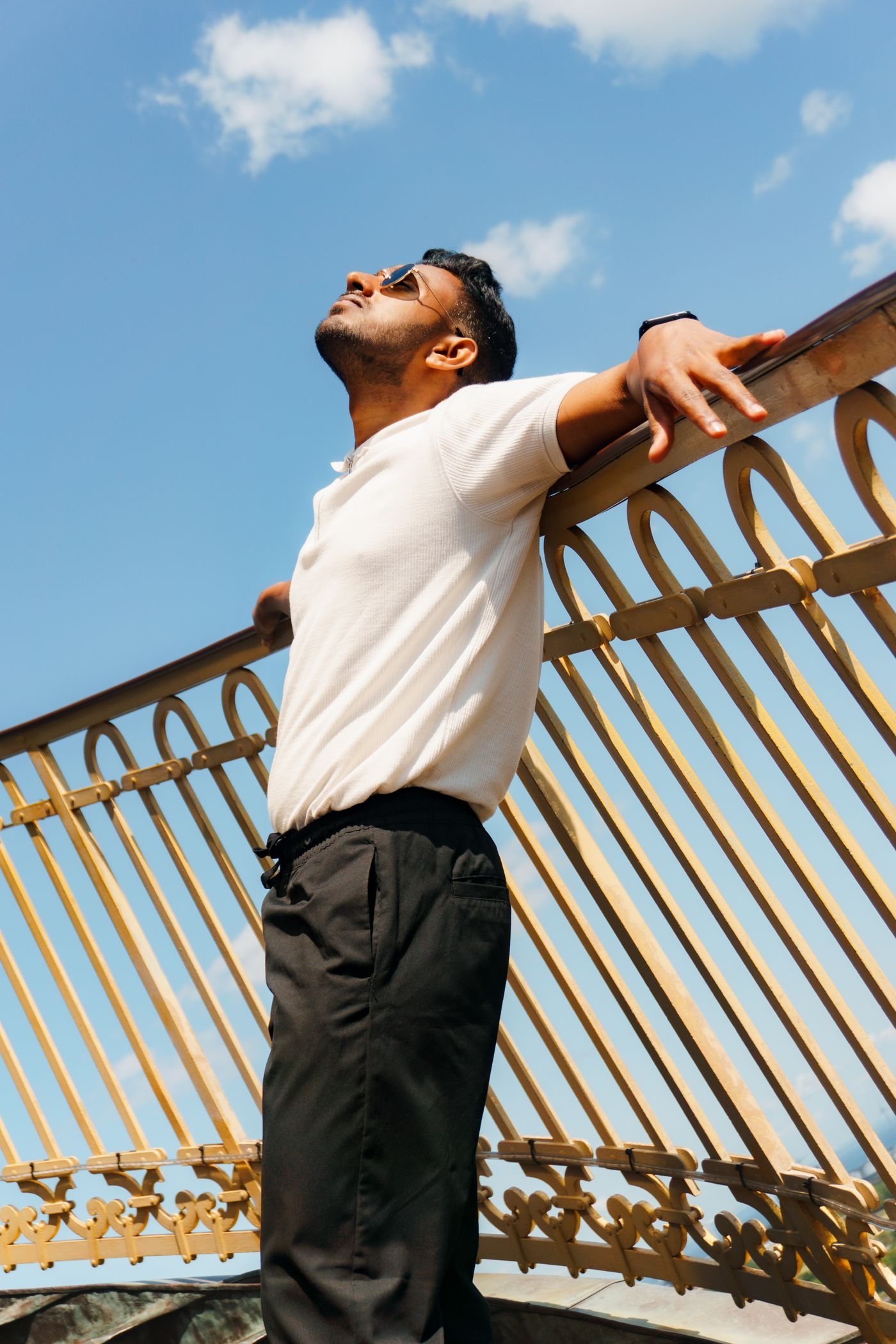 Man enjoying sunlight outdoors with arms outstretched